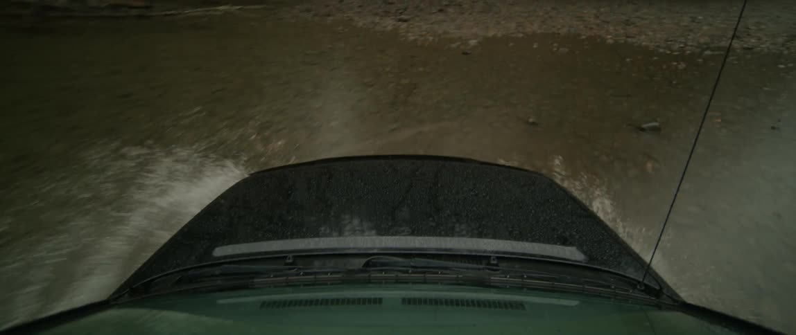A sport utility vehicle drives over a river