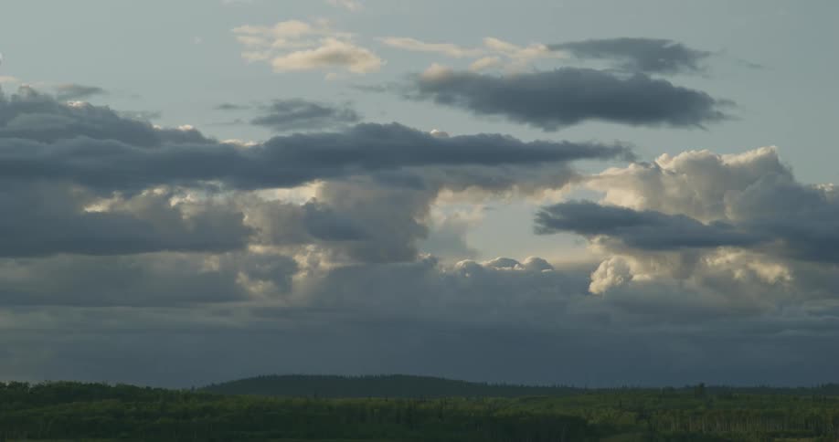 Sunlight shines through dense clouds over a field