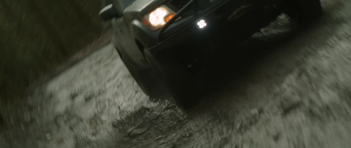 A sport utility vehicle drives through a creek in the woods