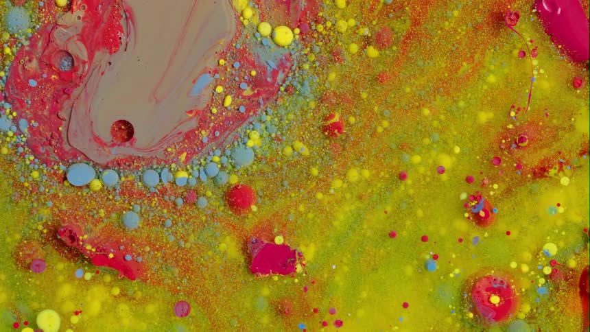 An organic liquid substance comes to life on a chartreuse background as gray moves in and light blue and yellow dots move away from the blending red