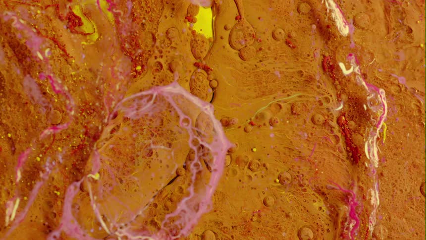 Yellow and pink wisps move across the rough orange terrain