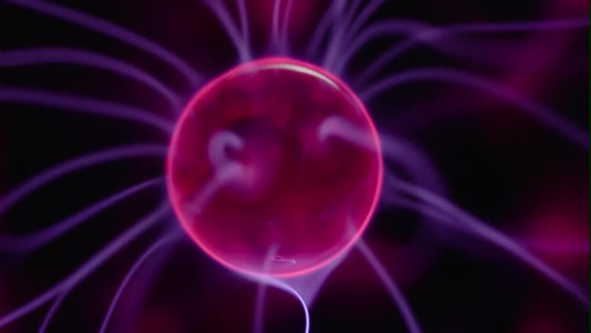 A bright pink sphere is floating and rotating as purple wisps of light from inside spread out and move