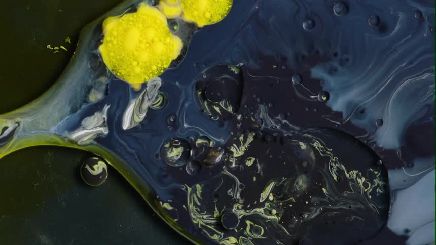 Dark blue and yellow paints combine to form a marble pattern