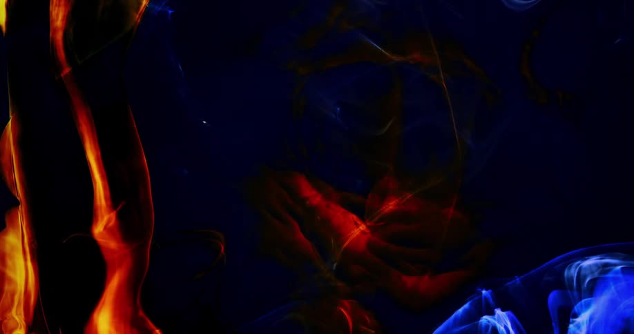 Glowing reddish orange whisps explode in the darkness as a blue wisp is in the distance