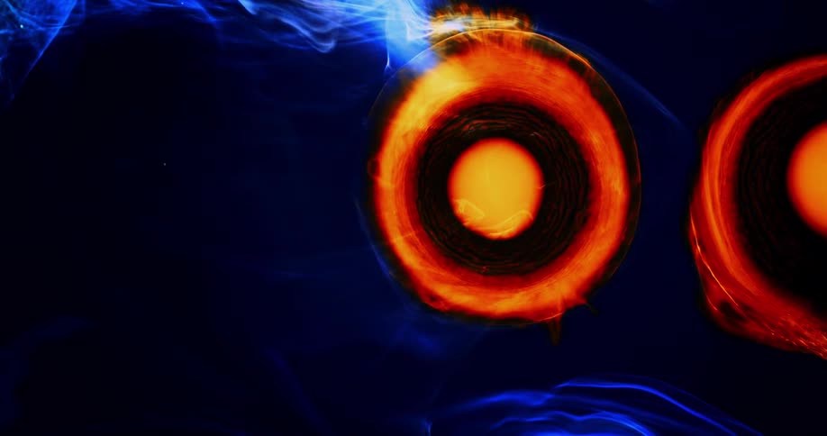 Circles of orange and yellow burst outward and expand against blue and black