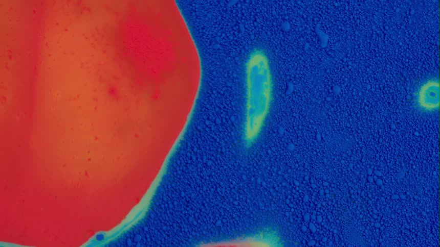 An orange fluid is flowing upwards through the surface of a blue fluid