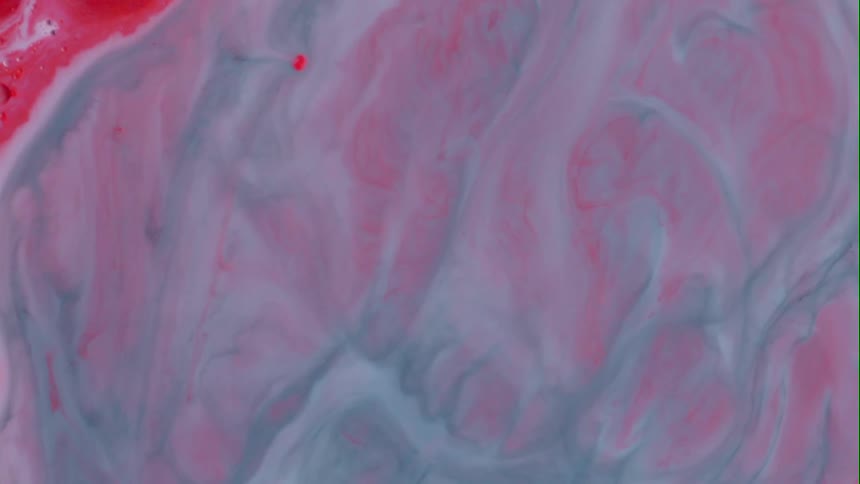 Red and white paint combine to form pink swirl patterns