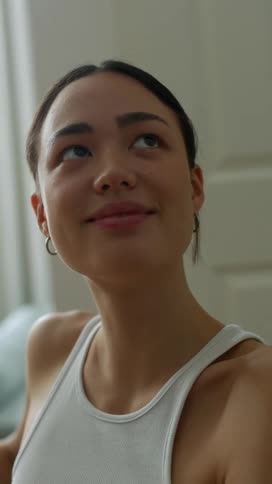 A woman at home looks up and talks and smiles