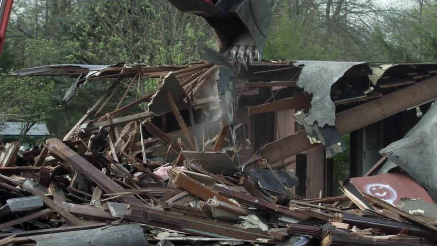 A construction vehicle is demolishing a house