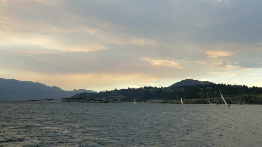 Sail boats are anchored by the shore