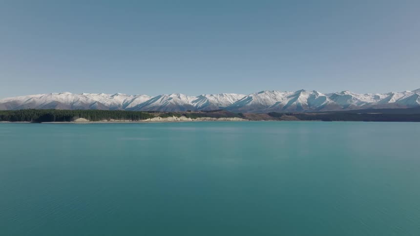 A thick blanket of snow covers a mountain range along the coast