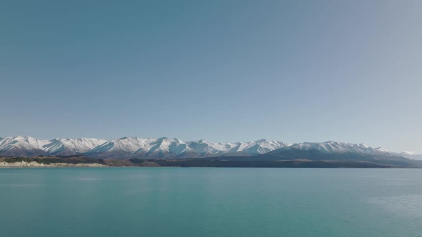 Aerial view of an ocean near mountains is displayed