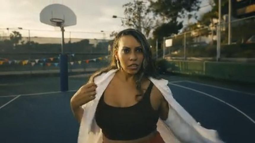 Woman dances on roller skates across a basketball court