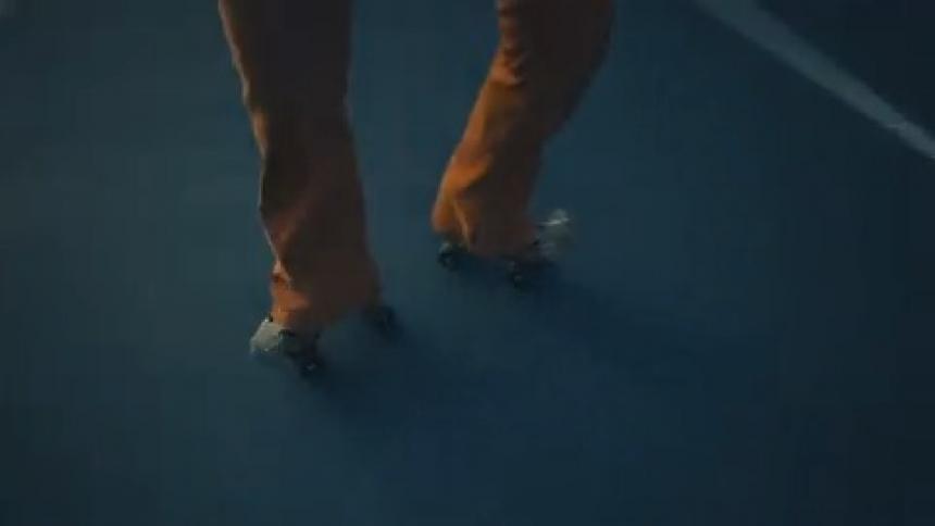 A person is roller skating in circles on a basketball court