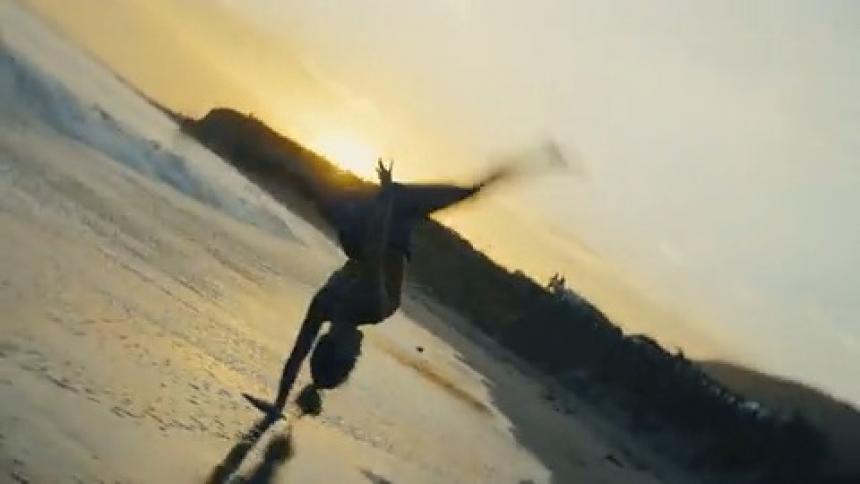 The camera spins with a woman doing flips on the beach