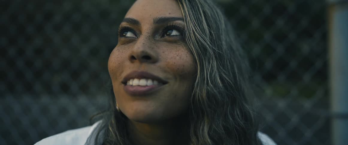 A woman looks up at the sky and smiles
