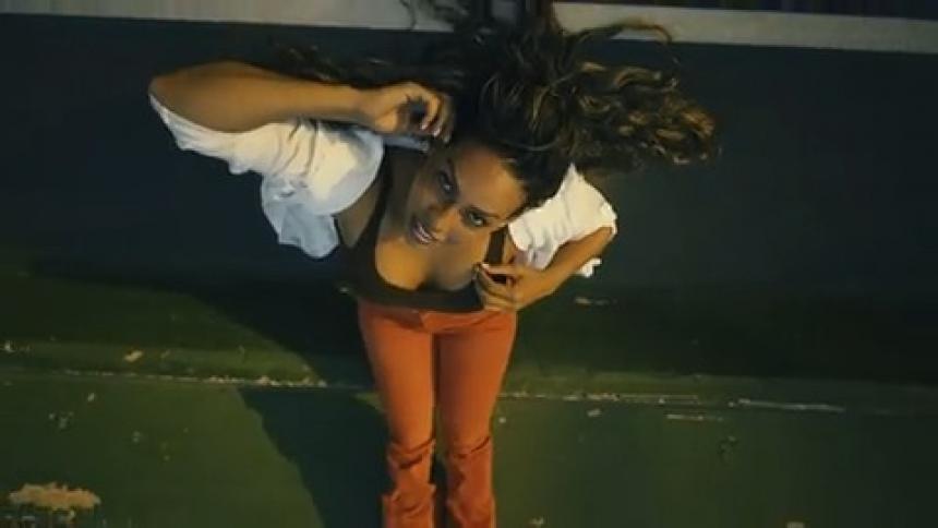Camera spins as it pulls away from a woman lying on a basketball court