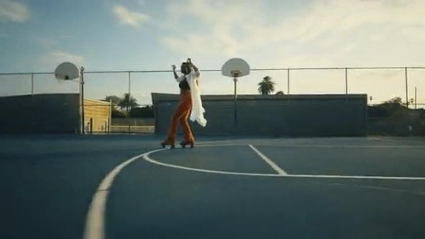 Camera rushes in toward woman roller skating