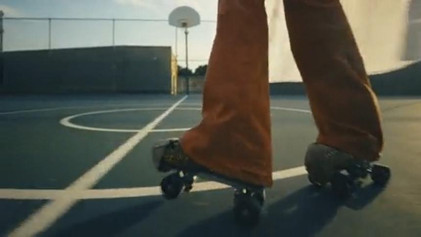 A woman's roller skates playfully dance over a basketball court