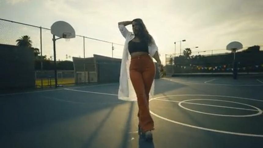 Woman dances while rollerskating across a basketball court