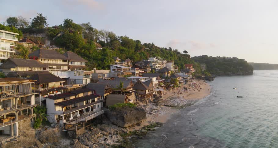 Aerial view of coastal town and people on the beach at dusk