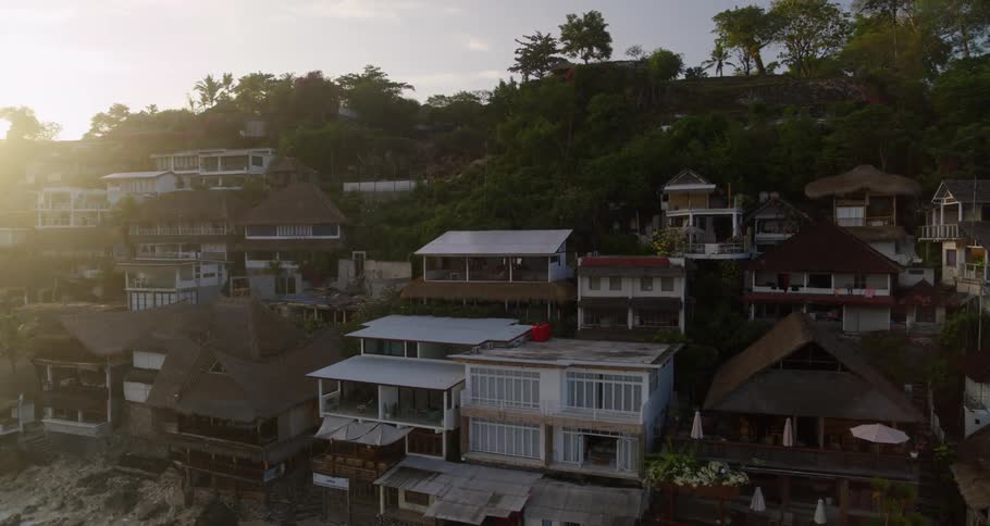 Aerial view of coastal town with buildings near the beach at sunset