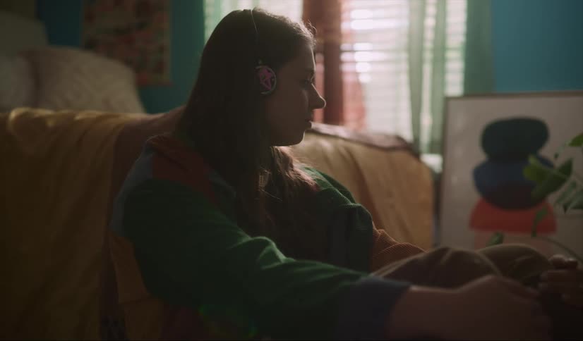 A girl is listening to headphones at home