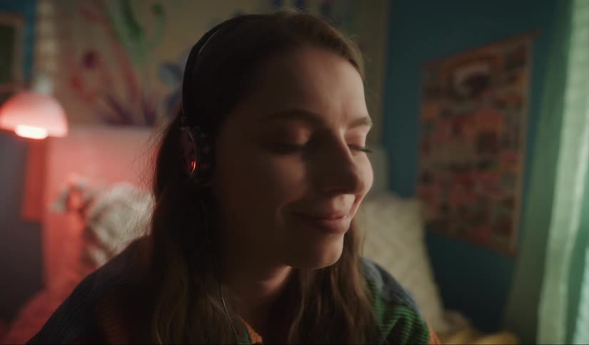 A girl smiles while wearing headphones
