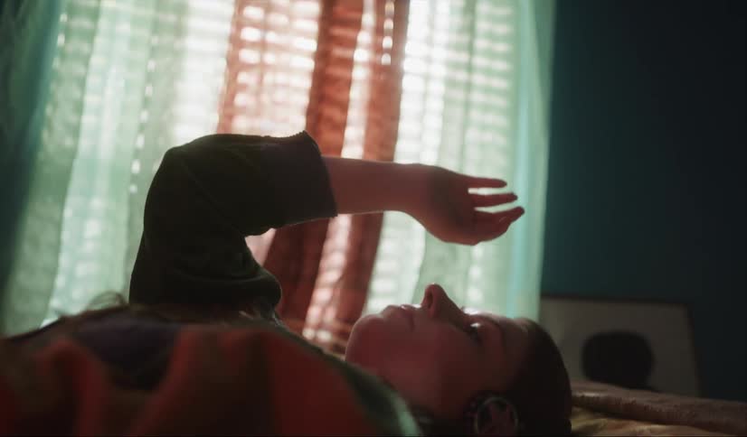 A woman laying in a bed stretching