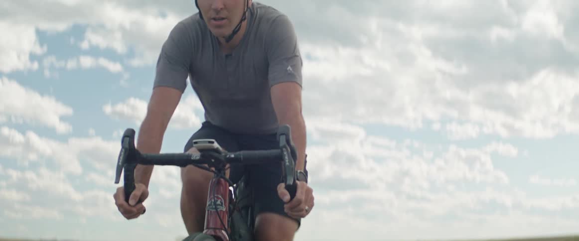 Male cyclist with black helmet shortys and gray t shirt cycles on highway