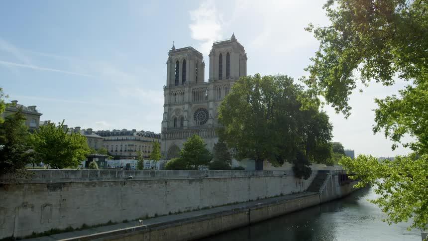 A large building with a clock is near the canal