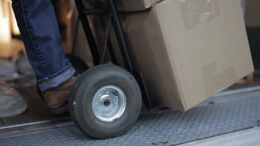 Boxes are stacked on a hand truck before being wheeled off