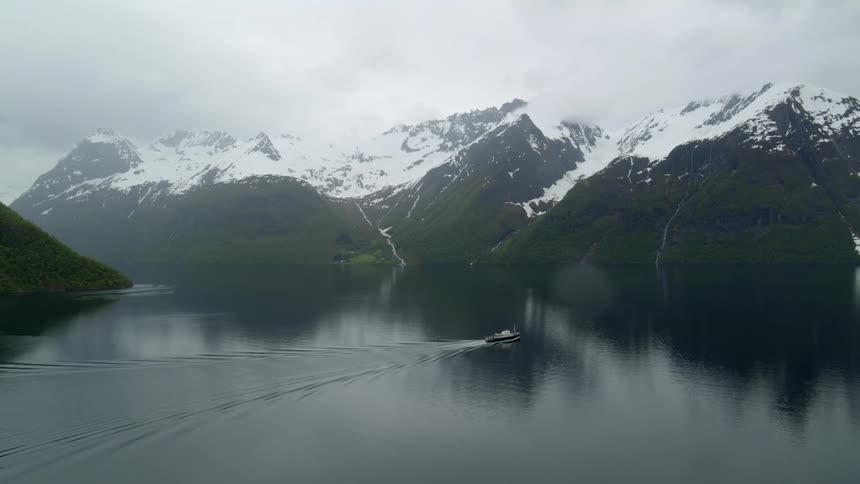 Aerial view of a ferry passing between mountains in Norway