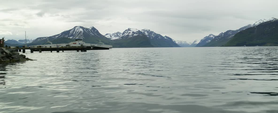A docked ferry in a Norwegian fjord sits peacefully