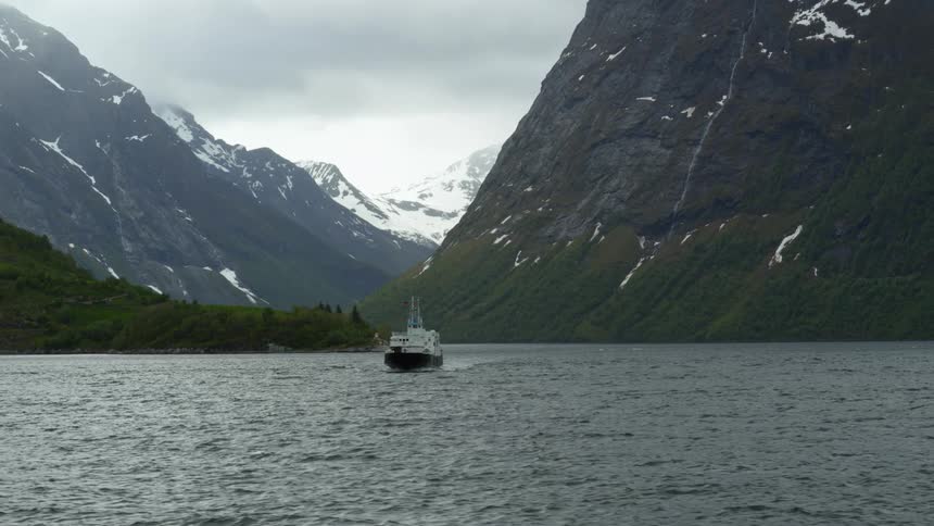 Drone captures ferry passing between fjords in Norway with epic mountains