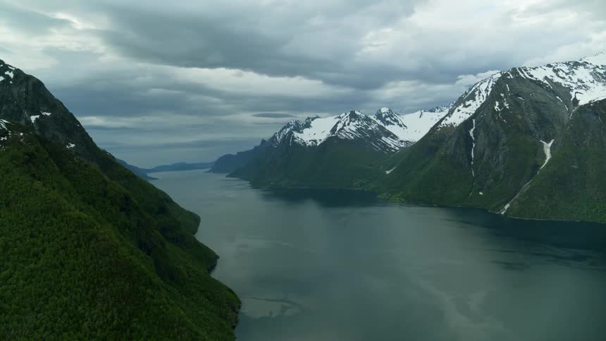 Beautiful aerial view of Norwegian fjord land with snow capped mountains and glacial waters