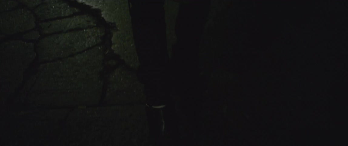 A person walks down a dark street