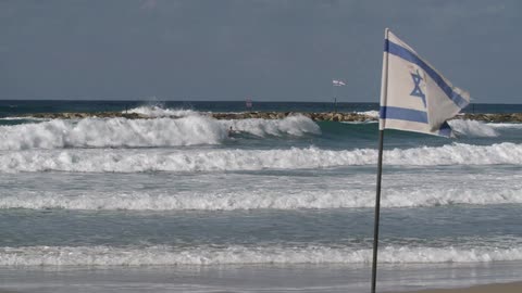 A flag is blowing in the wind of a beach