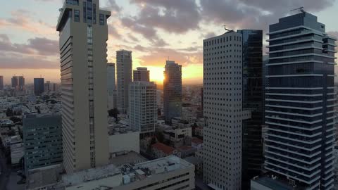 Skyscrapers stand tall against a sunset