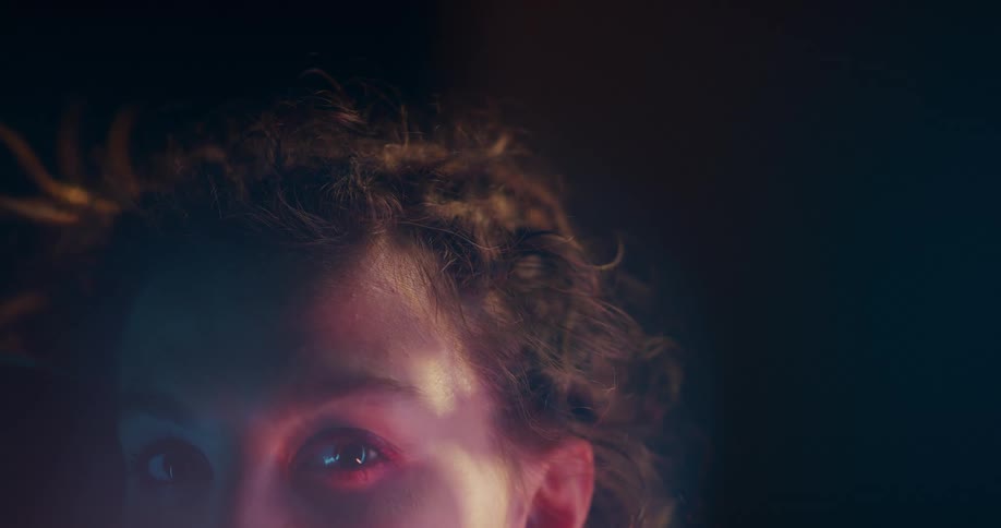 Sunlight shines on the side of a womans face as she turns her head
