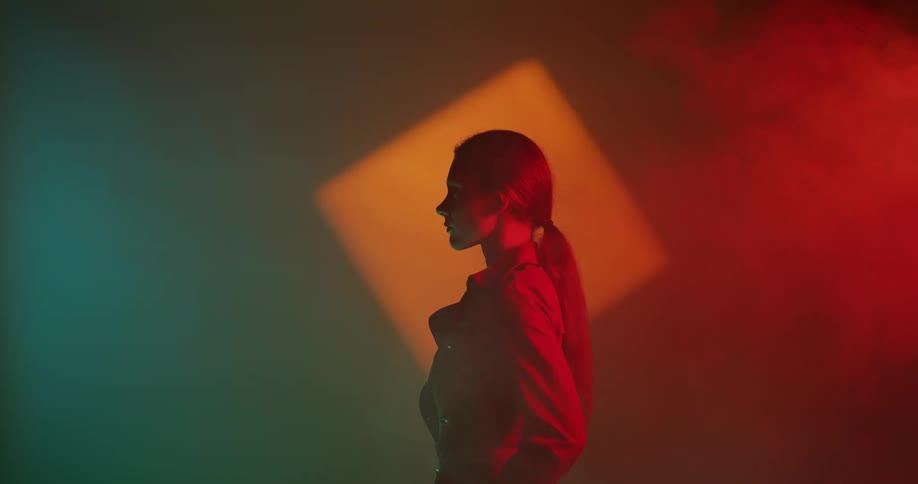 A woman is standing outdoors with during night