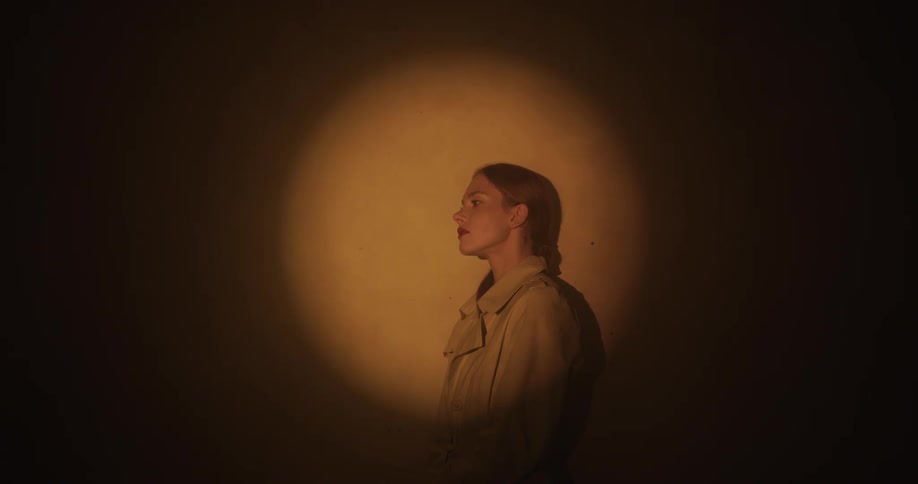Relaxed woman reclined on a wall under a soft spotlight