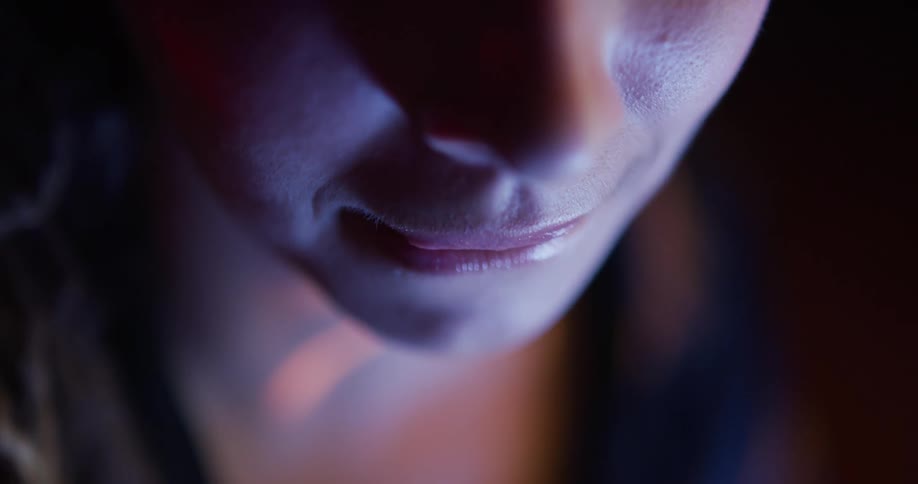 A very close up view of a womans mouth and nose show her smiling in slow motion
