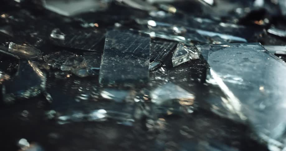 Close up of broken glass with police lights displaying on