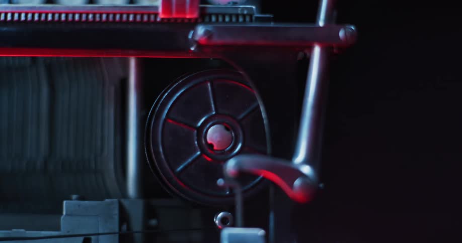 Close up of the rotating roll of tape on a working typewriter under red lights