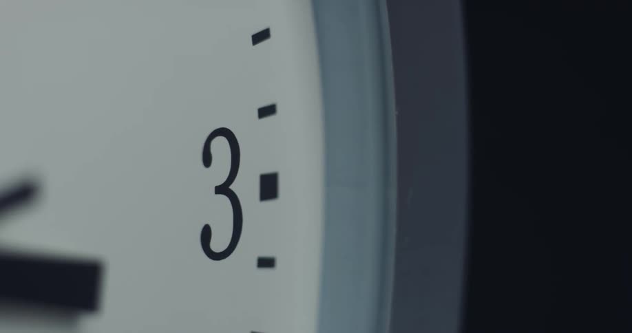 The hands of an analog clock move across the clock face