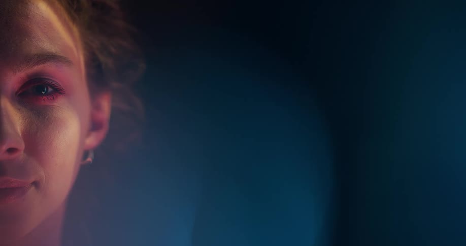 Light shines on the face of a teenage girl as she smiles