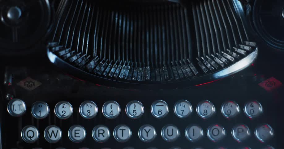 Light shines on an old typewriter as the type keys move up and down