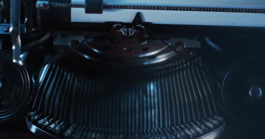Close up of the typebars of a vintage typewriter under blue lights