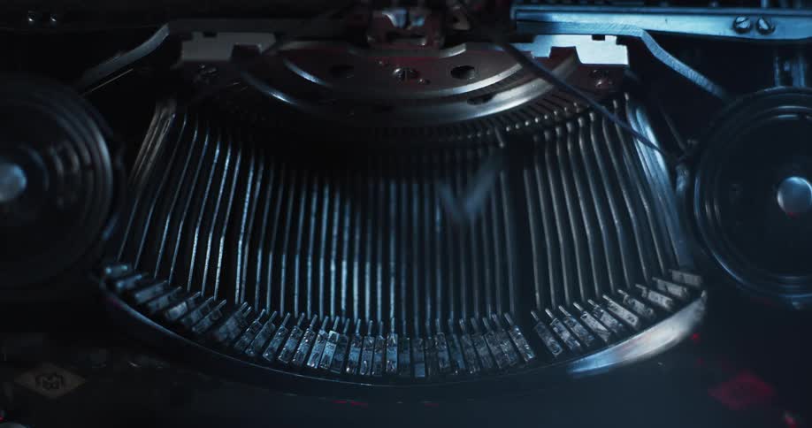 Light shines on an old antique typewriter as the strikers move as it types